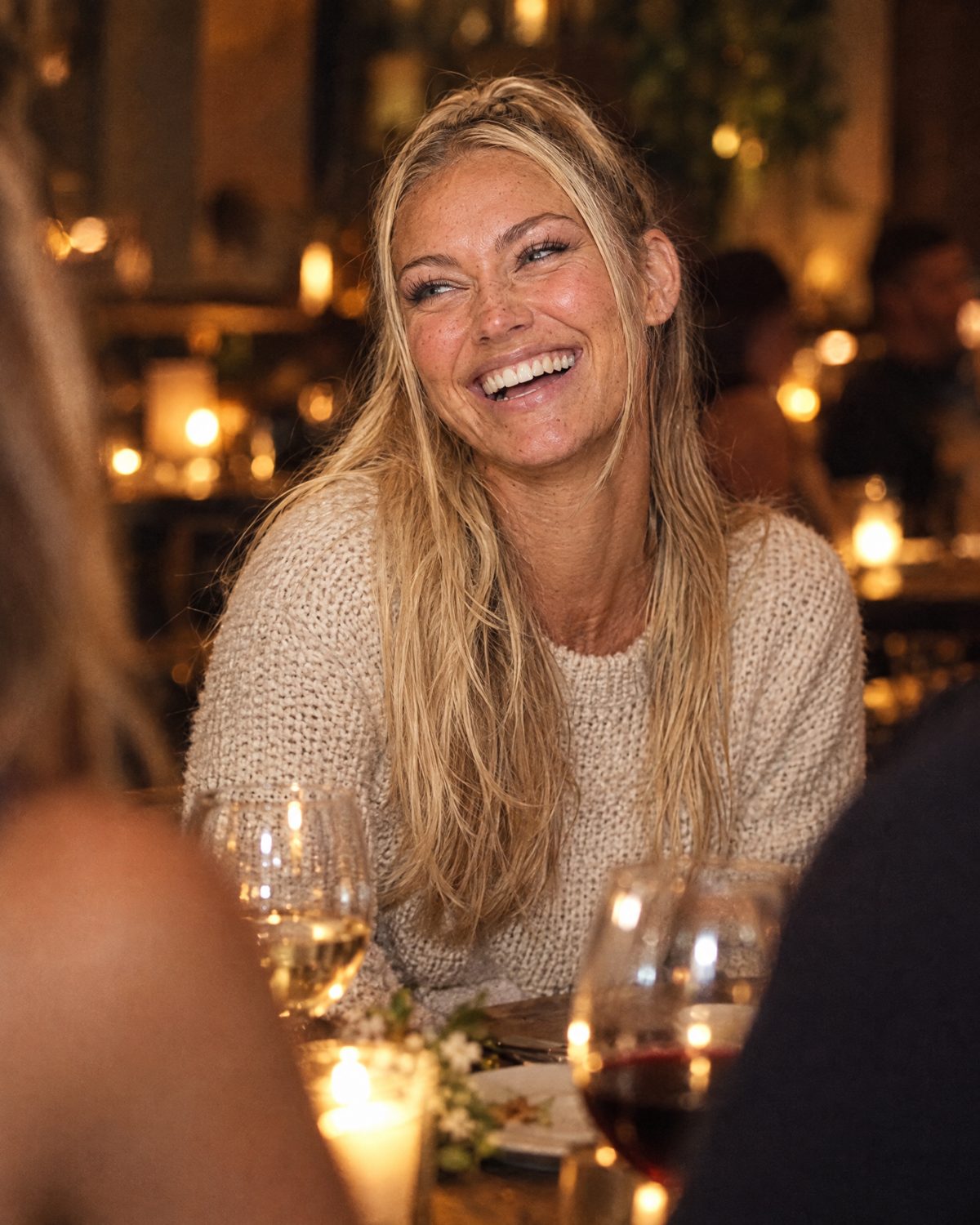Nina Vellin laughing at a dinner table with friends.